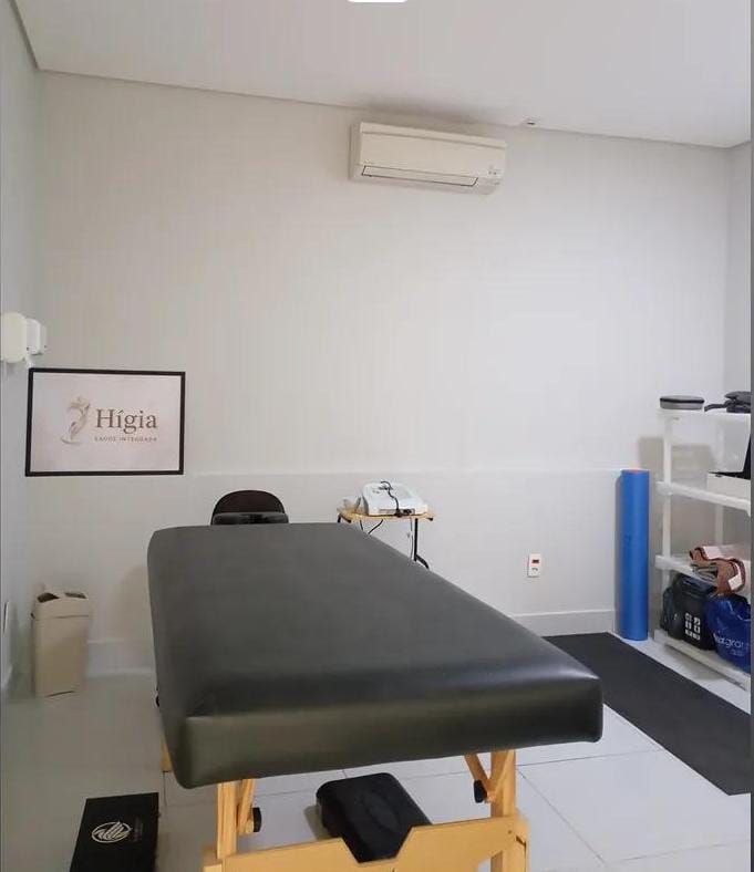 Sala de fisioterapia com maca, quadro com o logotipo da Hígia e materiais de apoio